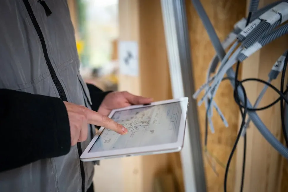 Electrician checking wiring plans on a tablet